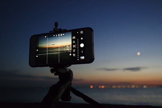 pexels-photo-93820-93820 An evening scene of a smartphone on a tripod taking a photo of the sunset over the ocean.